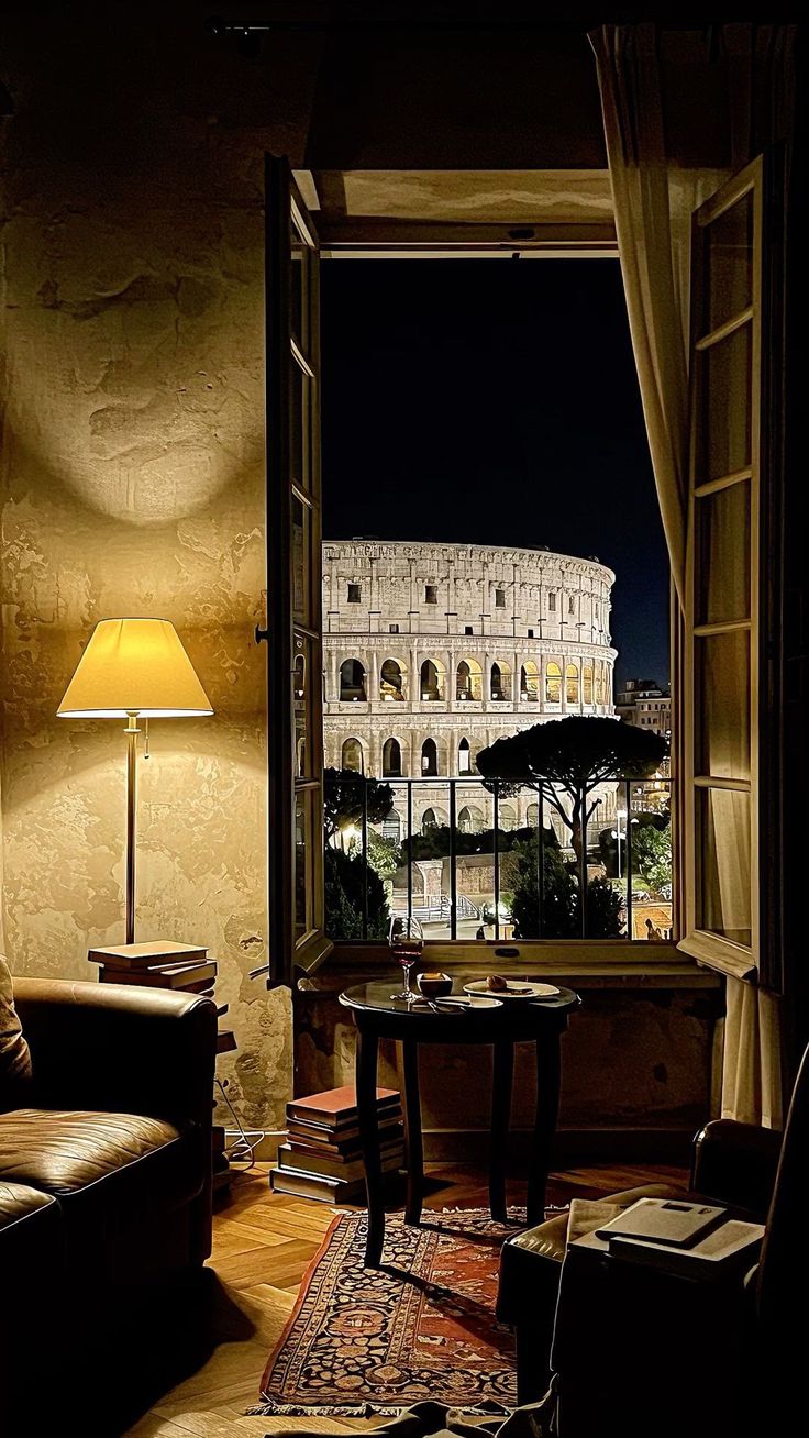 Roman hotel room with a window view of the Colosseum at night
