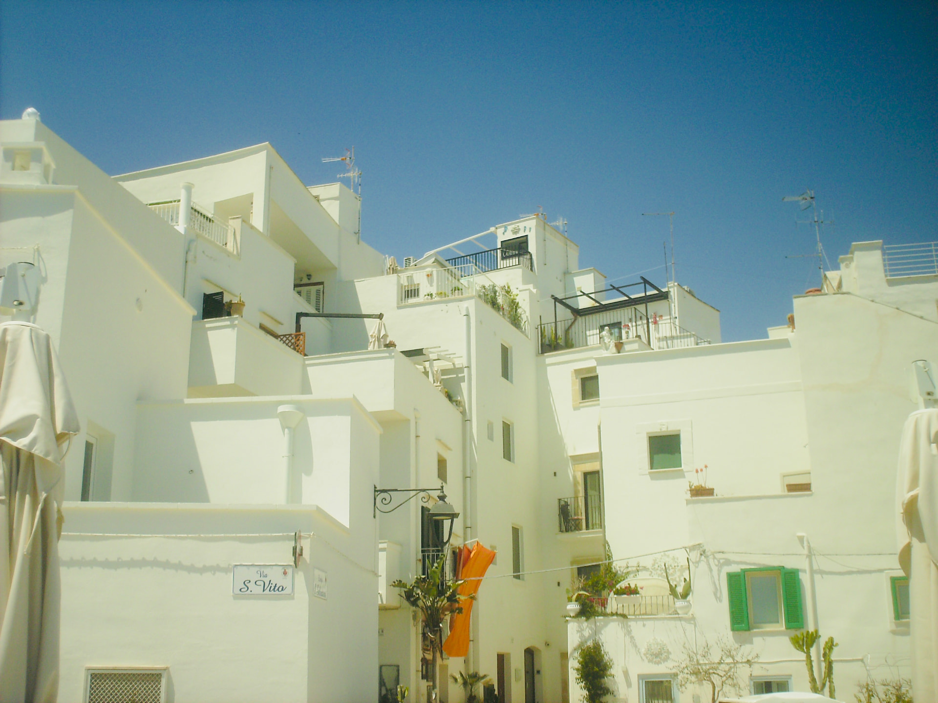 Whitewashed Italian village buildings under a deep blue sky